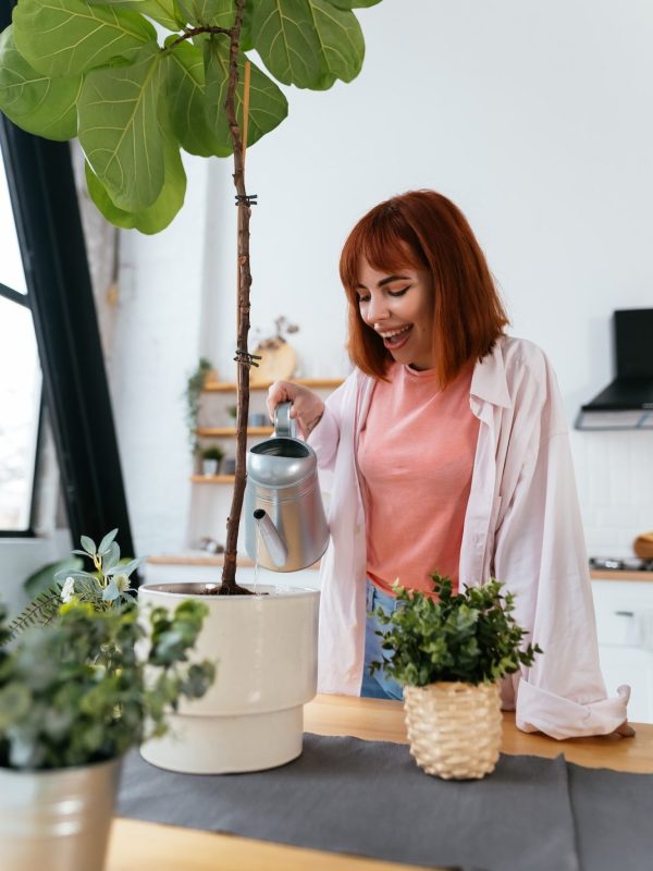 young-woman-pouring-water-in-flower-pot-with-indoor-houseplant-from-watering-can-.jpg